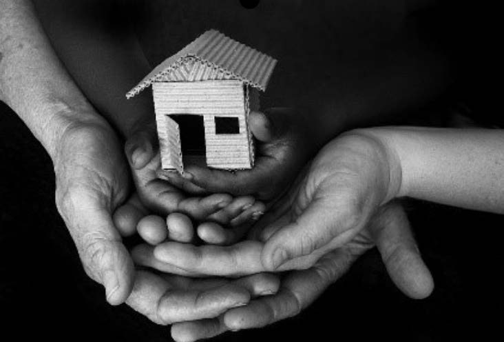 Hands holding miniature house