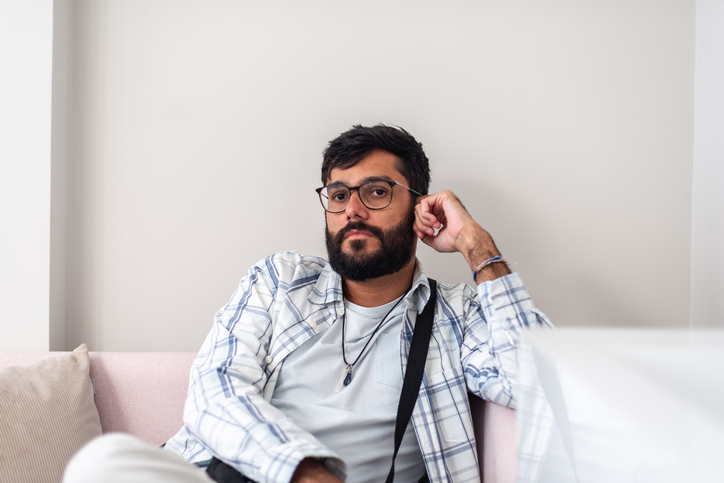 man sitting on sofa staring off