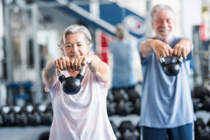 man and woman lifting weights