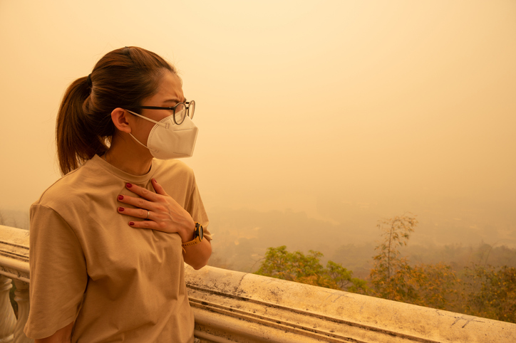 woman with mask facing wildfire smoke